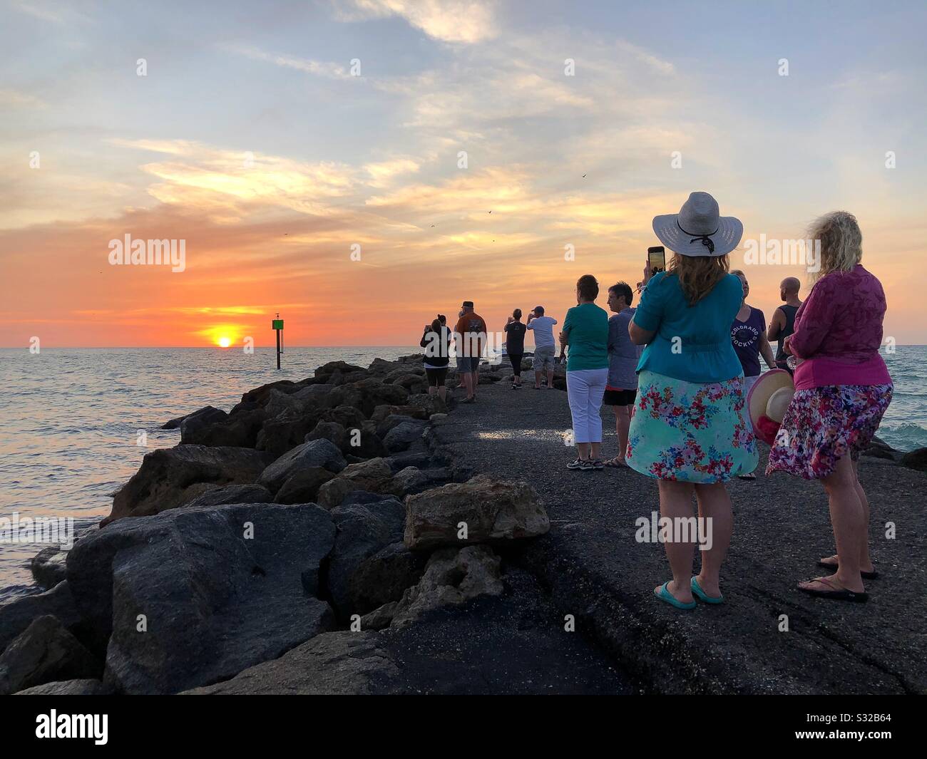 Un gruppo di persone si è riunito e guardando il tramonto a Sarasota, Florida, Stati Uniti. Foto Stock