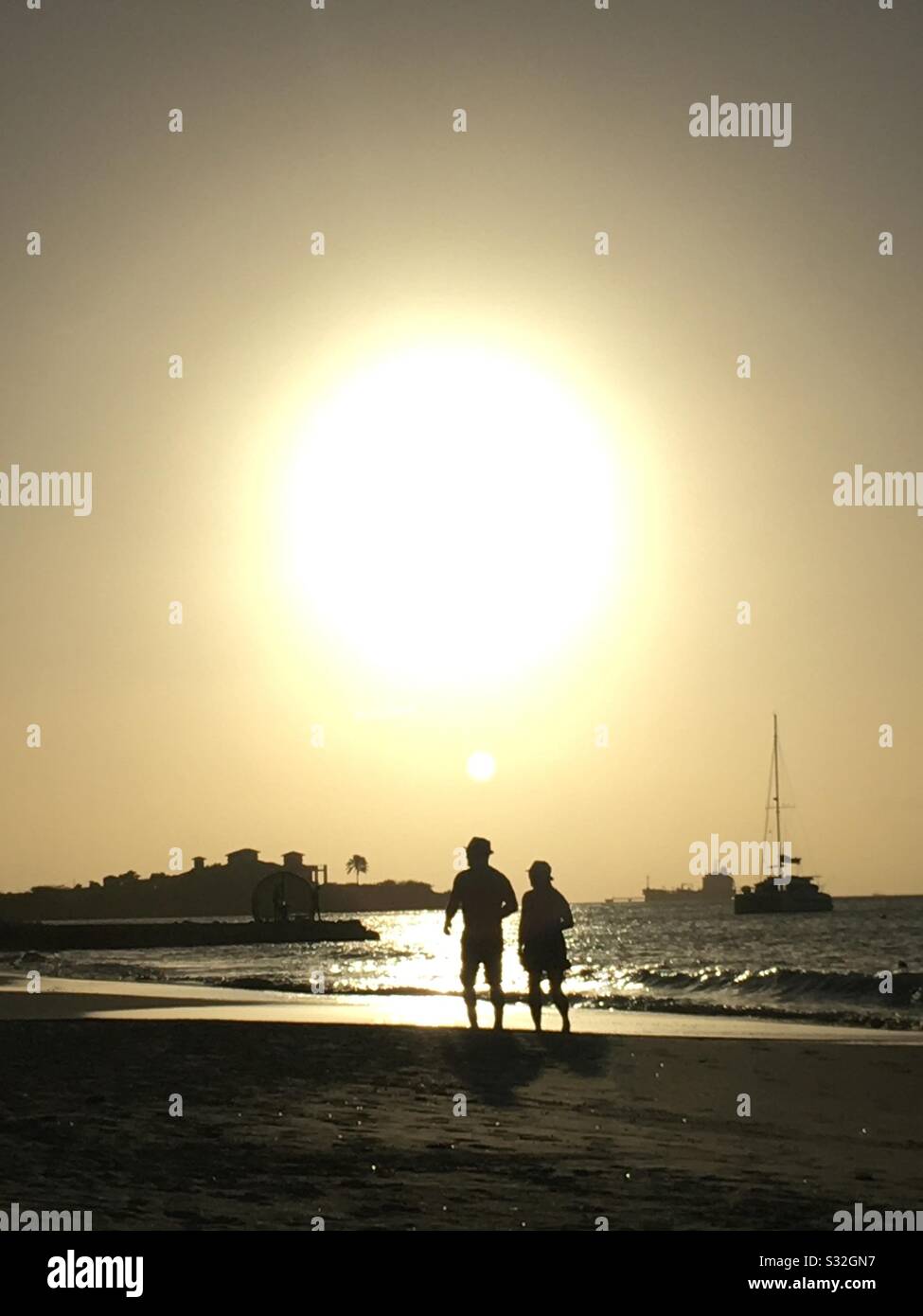 Coppia a piedi sulla spiaggia tropicale al tramonto Foto Stock