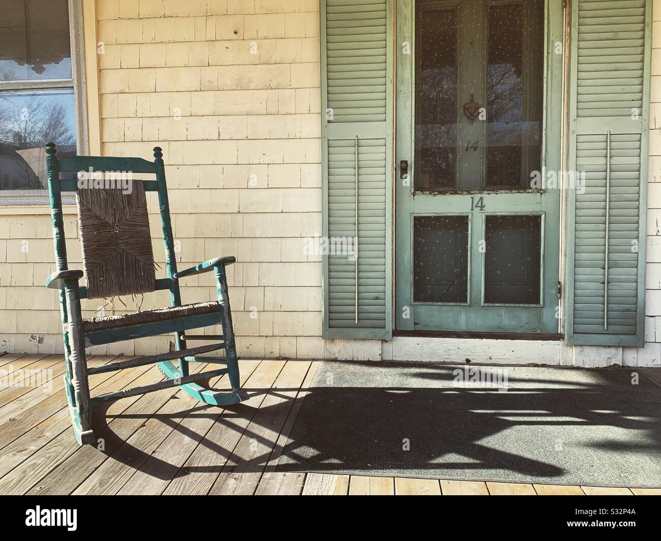 Vecchia sedia a dondolo sul portico di una vecchia casa a Woods Hole, Falmouth, Cape Cod, Massachusetts, Stati Uniti - Immagine stock catturata con smartphone