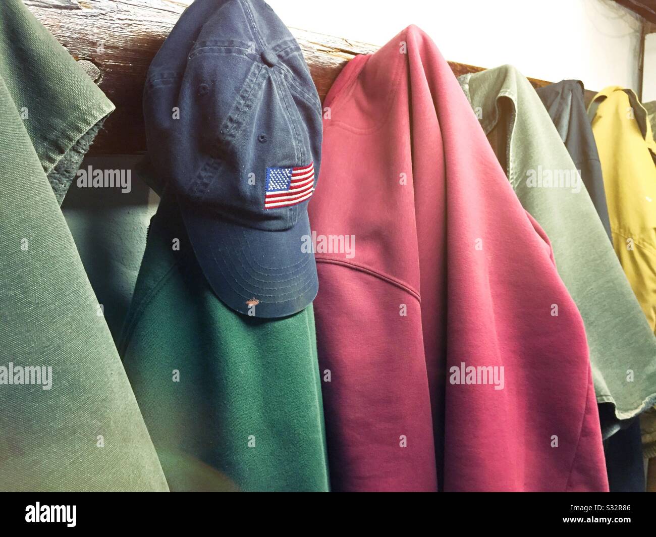 Appendiabiti riempito con abiti da lavoro e un cappuccio a sfera con bandiera americana, USA Foto Stock