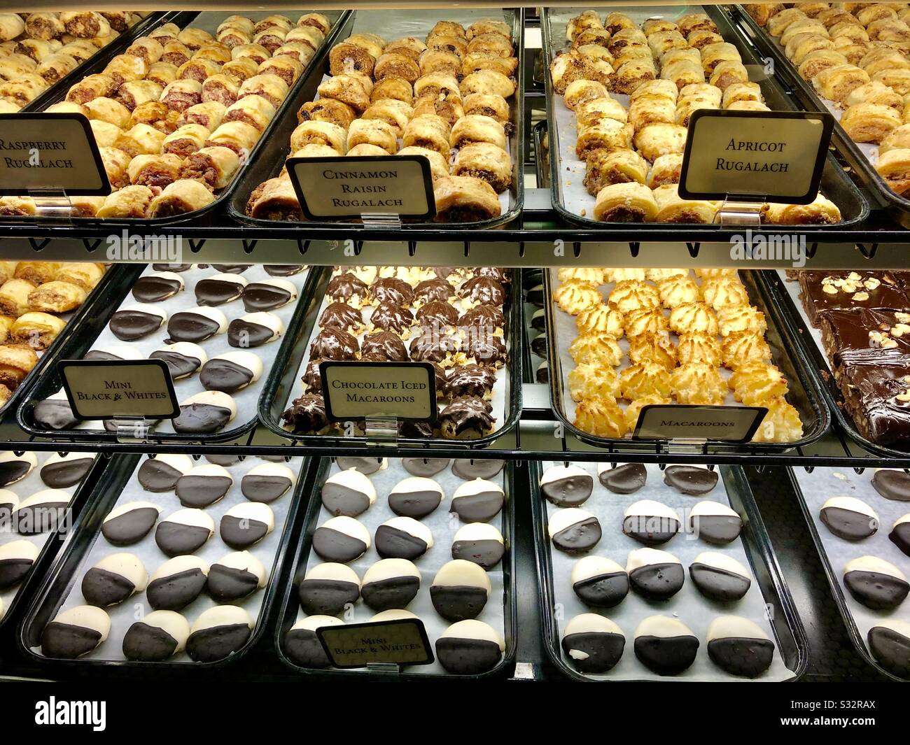 Espositore in un negozio di gastronomia e panetteria che mostra vari tipi di pasticceria e rugalach. Foto Stock Espositore in un negozio di gastronomia e panetteria che mostra vari tipi di pasticceria e rugalach. Foto Stock