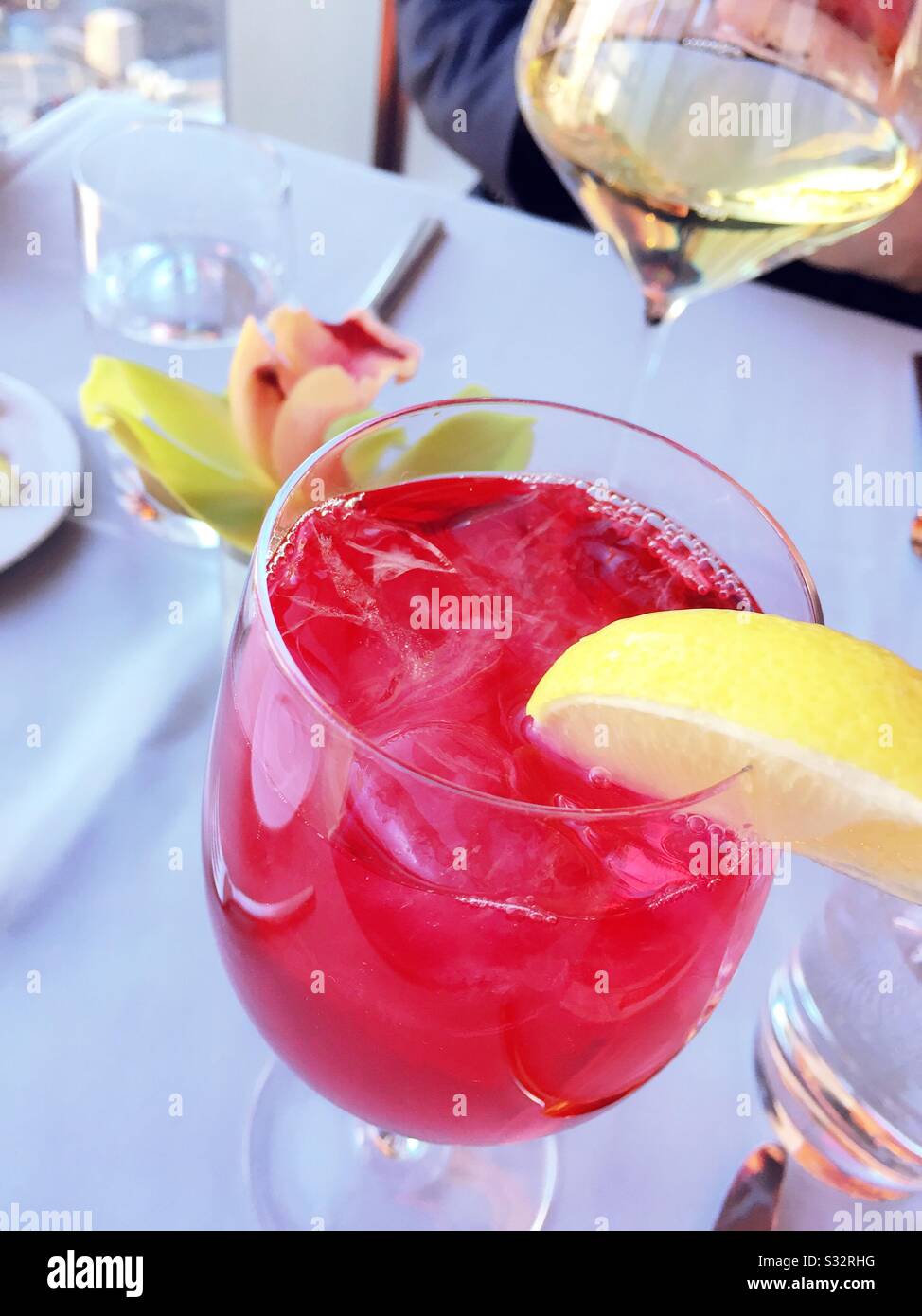 Speciale tè di ghiaccio aromatizzato e bicchiere di vino bianco in un elegante ristorante di New York City, USA - Immagine stock catturata con smartphone