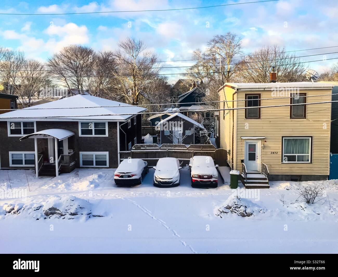 Una soleggiata mattinata invernale su una strada residenziale, con sole, neve fresca e cielo blu. Concetti: Fresco, grazioso, freddo tempo. Prima di sgombrare la neve. - Immagine stock catturata con smartphone
