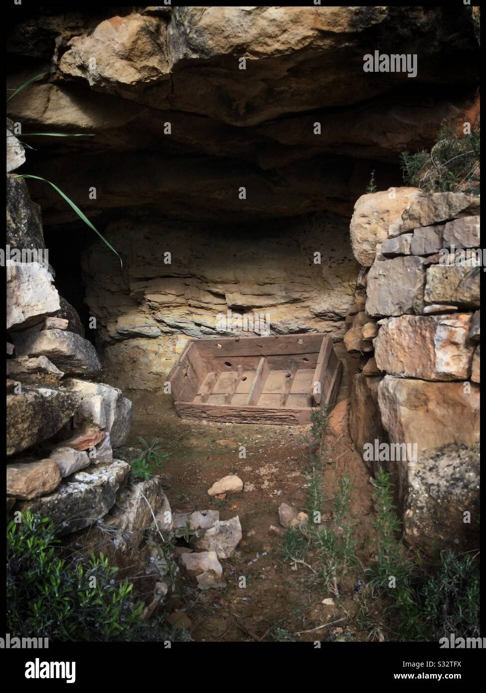 Rustico vino di legno (?) crate in un ingresso grotta, Catalogna, Spagna. - Immagine stock catturata con smartphone