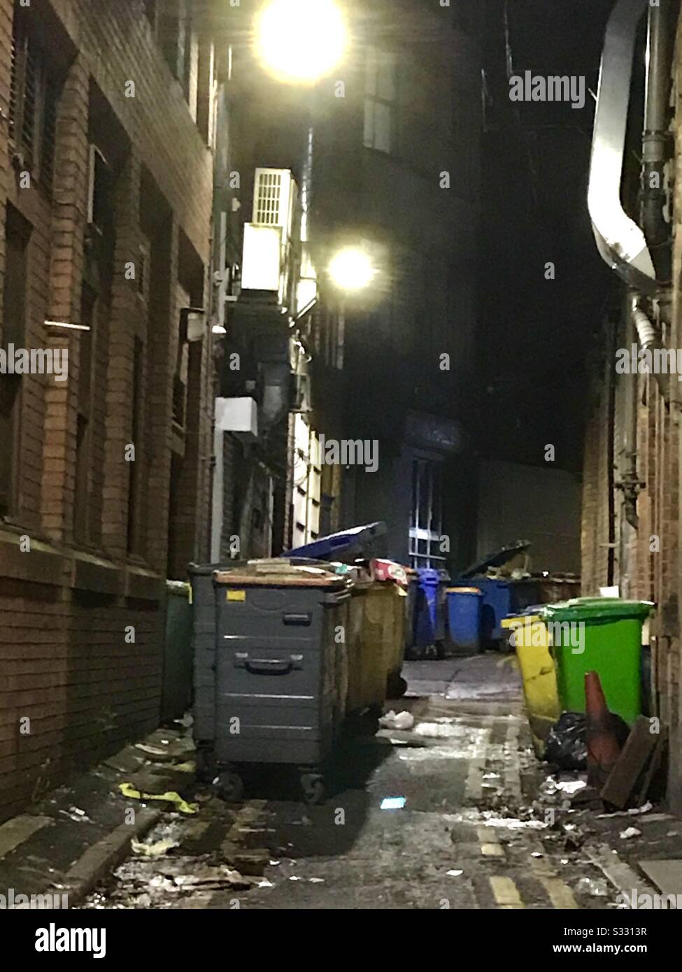 La triste vista di una strada laterale / vicolo con bidoni e lettiera. Non è un buon annuncio per "binning it "! Foto Stock