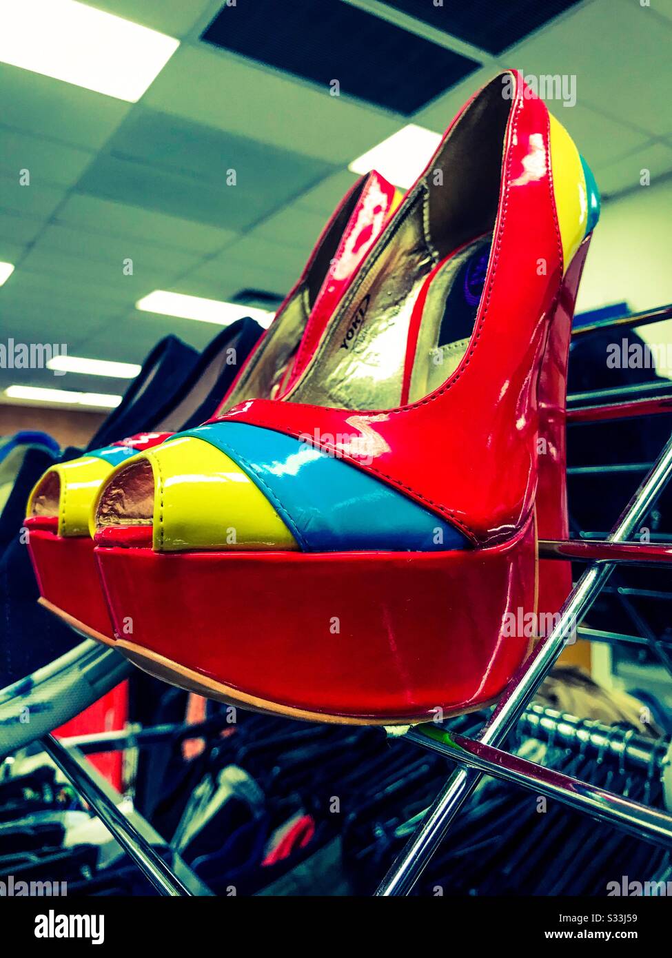 Scarpe da tacco con plateau rosse lucide e vivaci su una rastrelliera in un negozio di successo Foto Stock