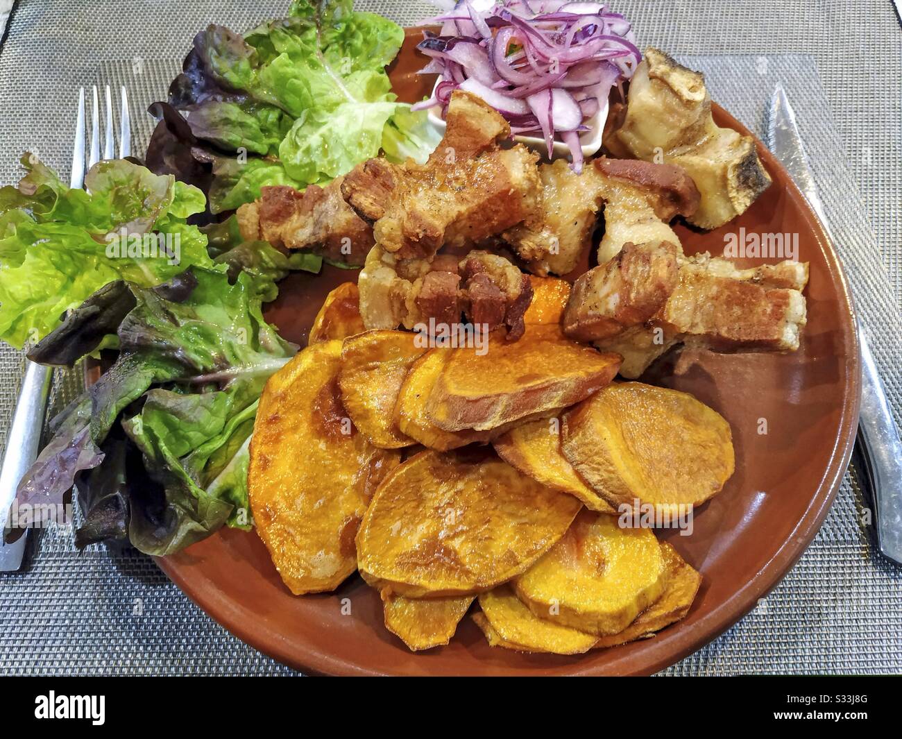 Chicharrones con patate dolci. Piatto tipico del Perù. Foto Stock