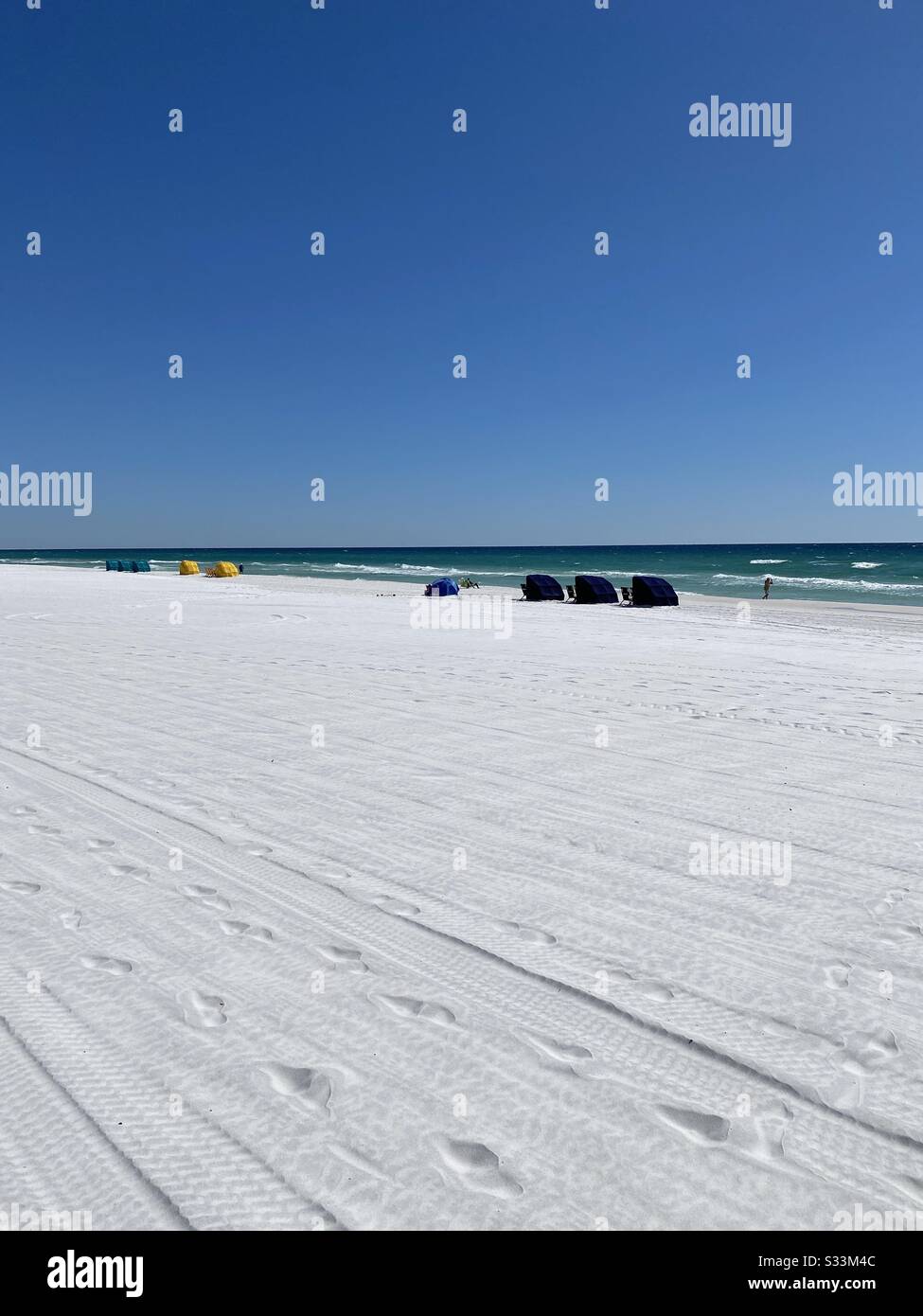 Spiaggia di sabbia bianca in un giorno invernale con capanne sulla spiaggia e vista sull'acqua smeraldo del Golfo del Messico Foto Stock
