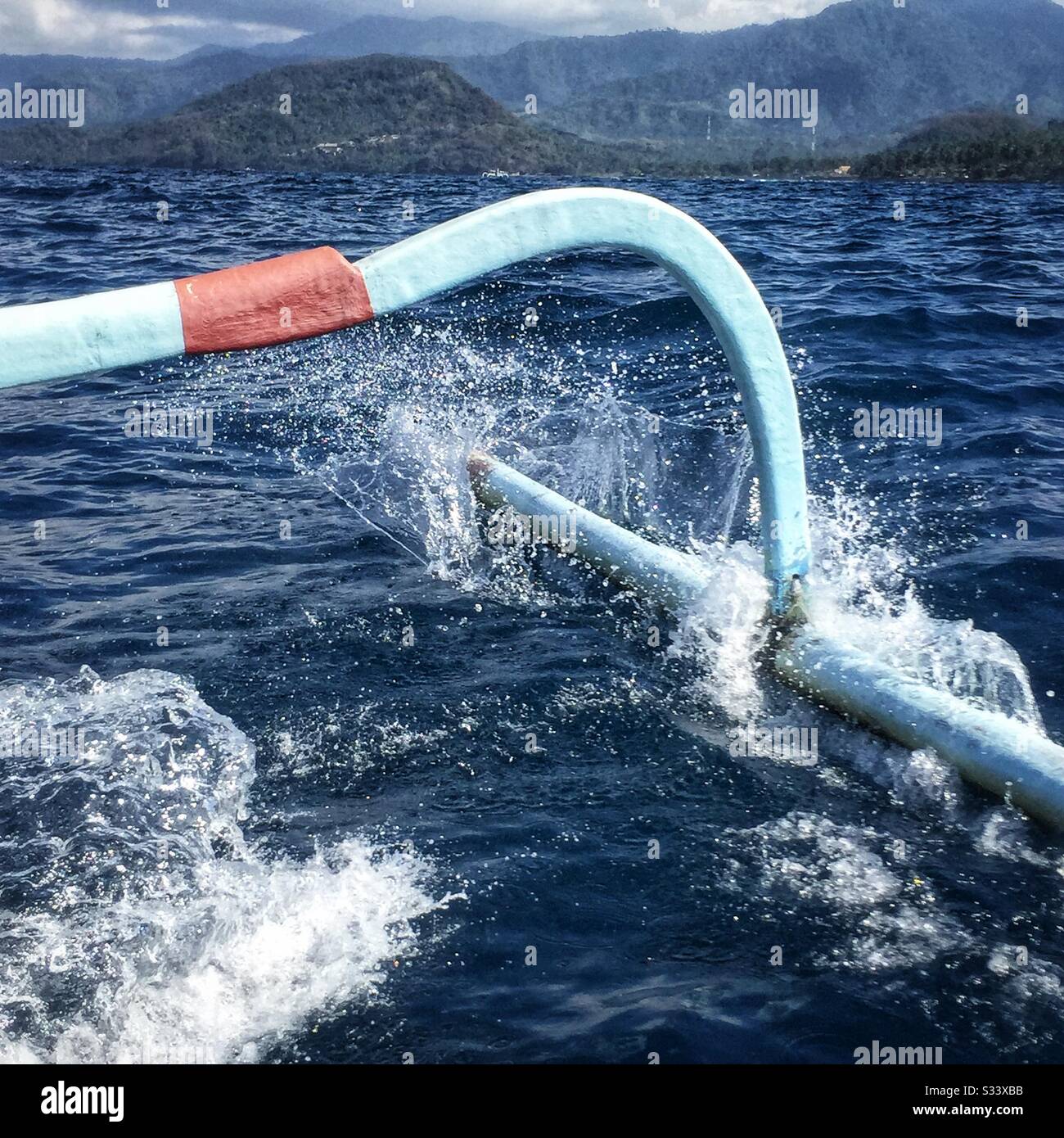 Outrigger di tradizionale barca da pesca Balinese, usato anche per i turisti in traghetto per escursioni turistiche, immersioni o snorkeling, al largo di Candidasa, Bali, Indonesia Foto Stock