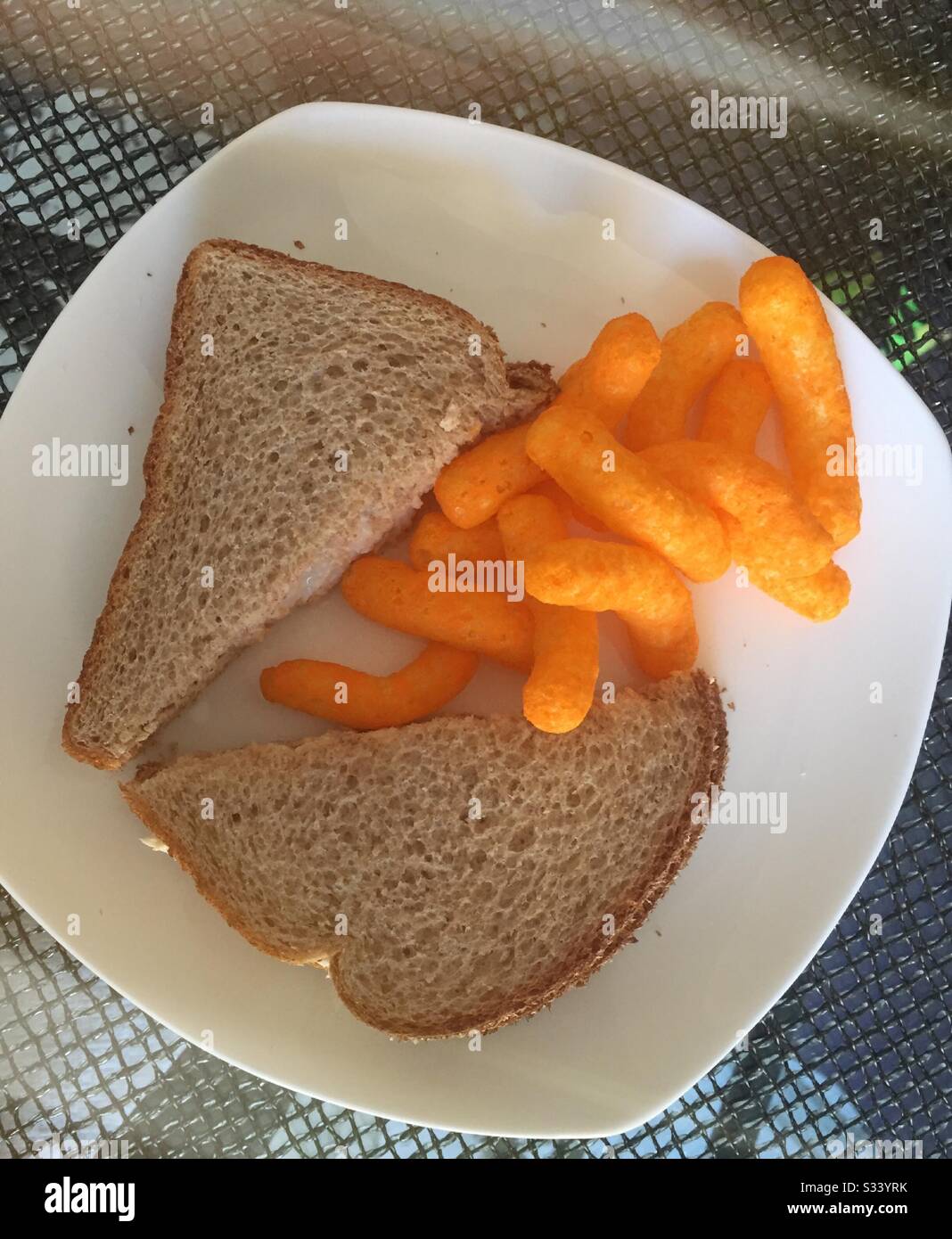 Piatto di un gustoso pranzo di panino di tonno su pane integrale di grano con croccanti ricci di formaggio arancio, USA Foto Stock