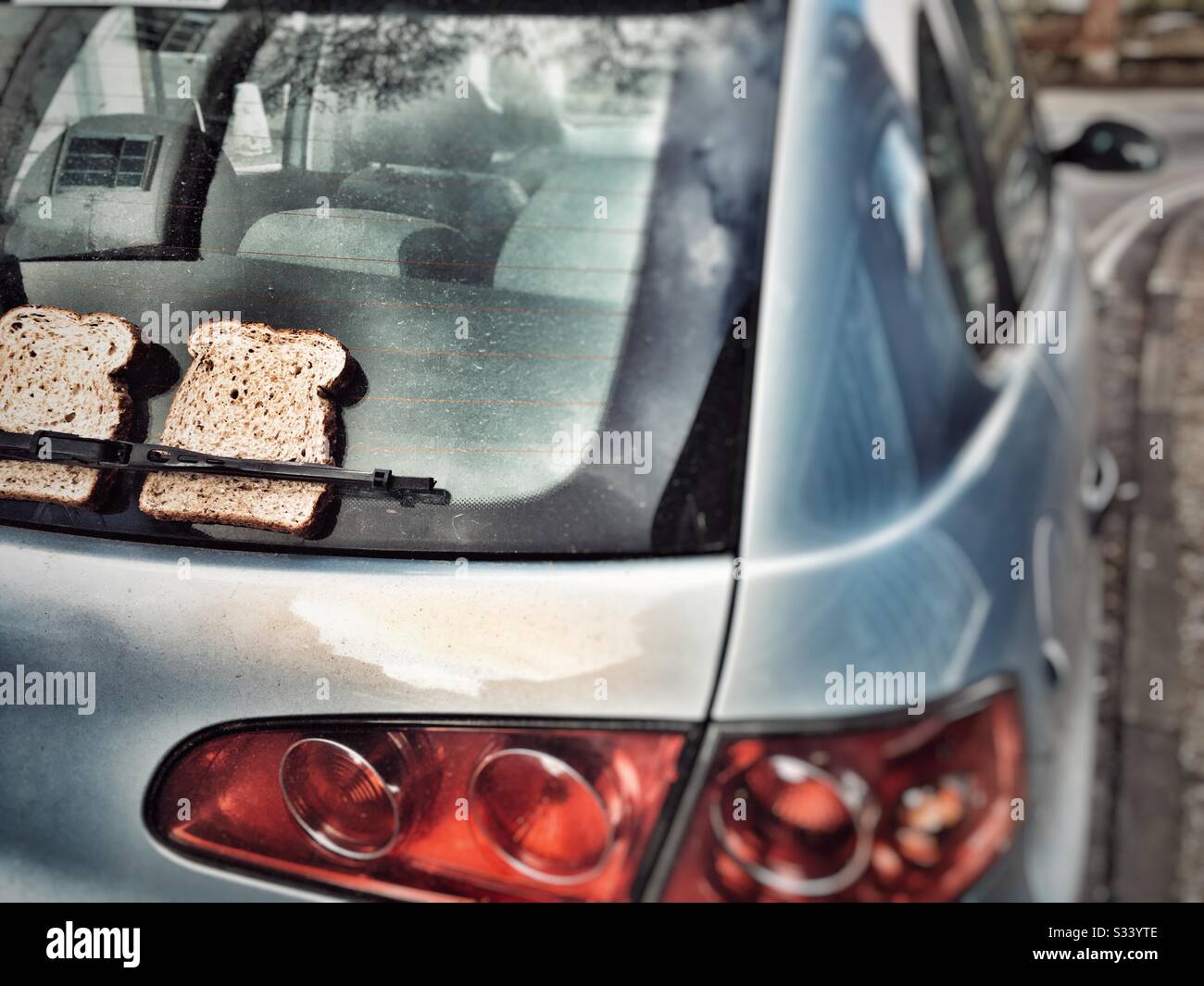 Pane affettato sotto la spazzola tergicristallo di un'auto parcheggiata Foto Stock Pane affettato sotto la spazzola tergicristallo di un'auto parcheggiata Foto Stock