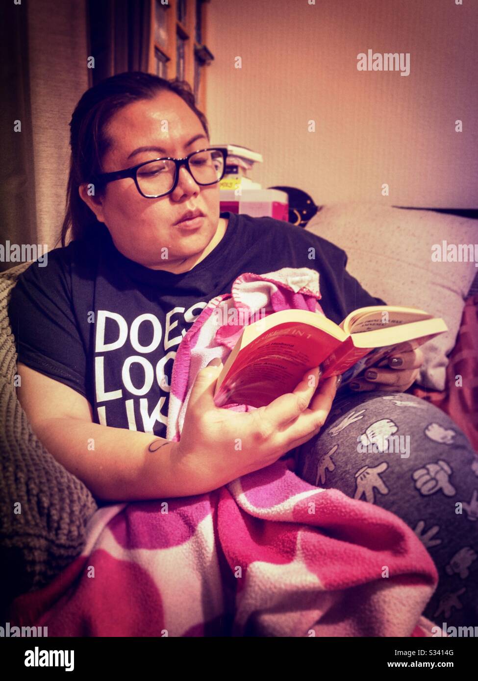 Una signora rilassante leggendo un libro. Foto Stock