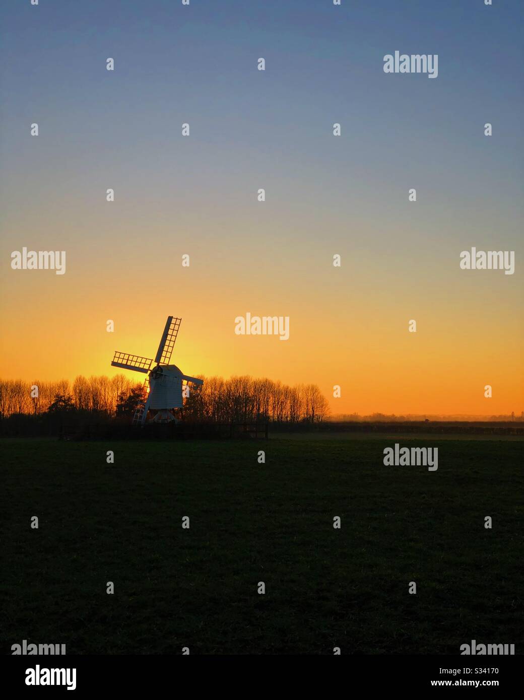 Silhouette di mulino a vento su collina con sole tramontare dietro. - Immagine stock catturata con smartphone