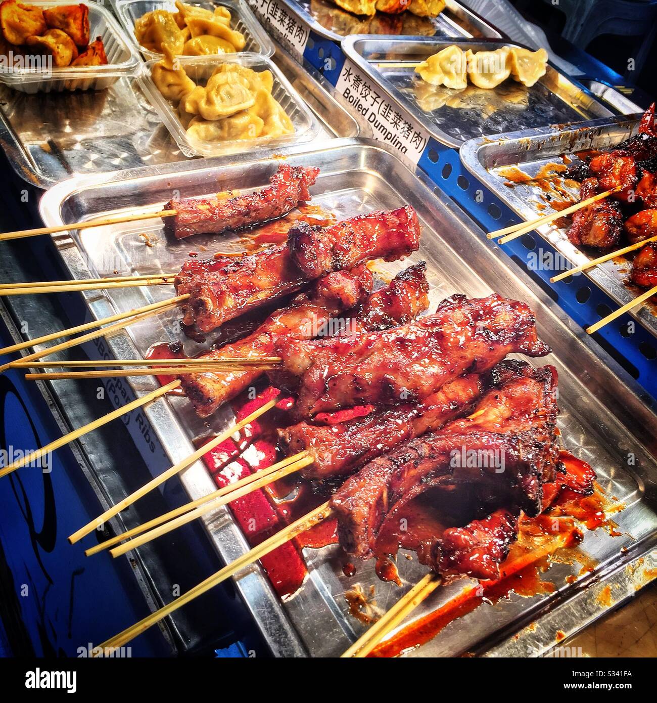Costolette di maiale barbecue in stile asiatico in vendita a Jalan Alor, un mercato alimentare hawker in Bukit Bintang, Kuala Lumpur, Malesia - Immagine stock catturata con smartphone