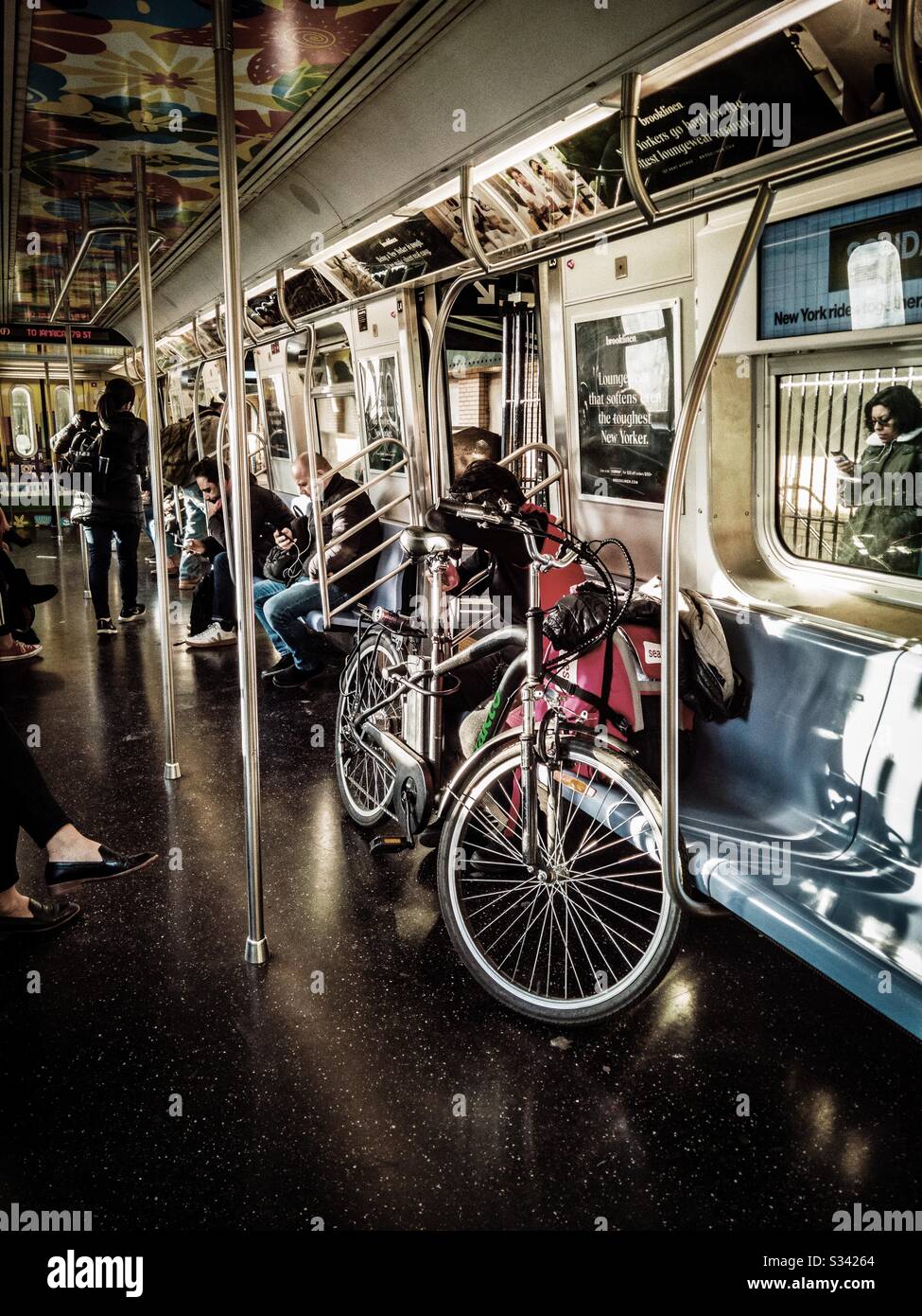 Passeggero che porta la sua bicicletta nella metropolitana Foto Stock