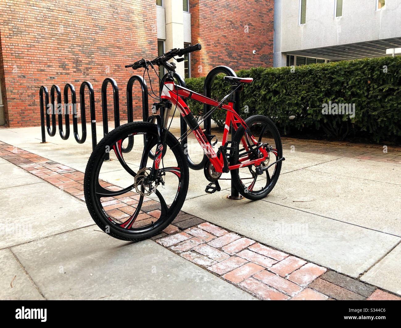 Bicicletta rossa su portabiciclette in città Foto Stock