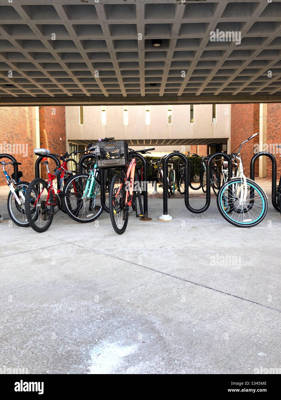 Biciclette in portabiciclette mentre i motociclisti sono al lavoro in città Foto Stock