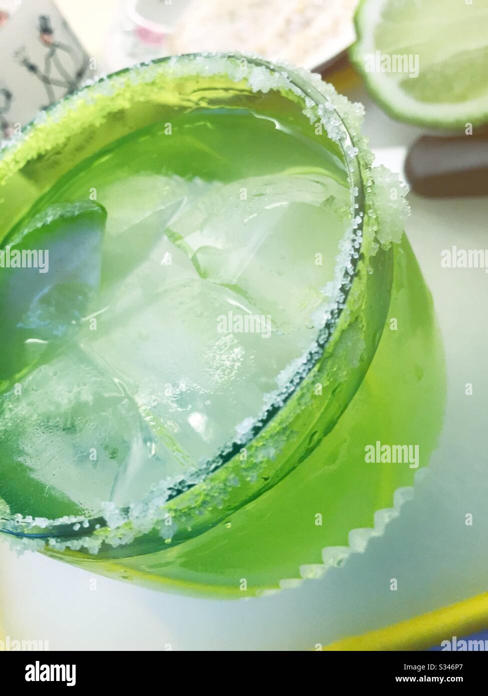 Primo piano di un cocktail margarita sulle rocce in un cristallo riimmed salato su una cucina residenziale tagliere con calce Foto Stock