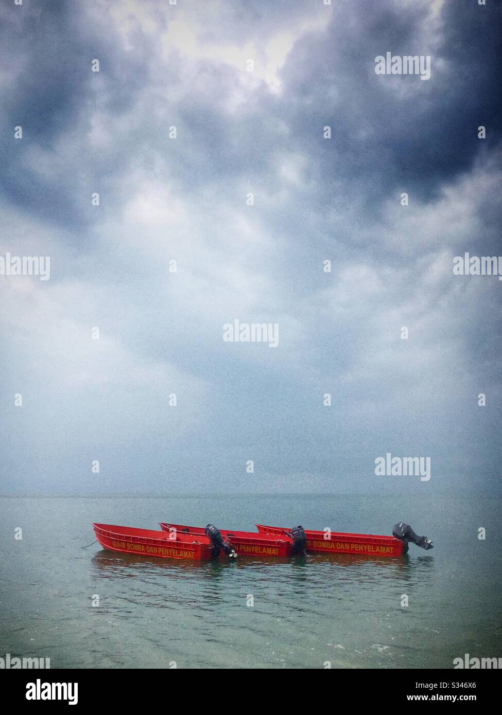 Fuoco e salvataggio barche ormeggiate della spiaggia sotto un cielo chiaro dopo mattina pioggia squall, Batu Ferringhi, Penang, Malesia Foto Stock