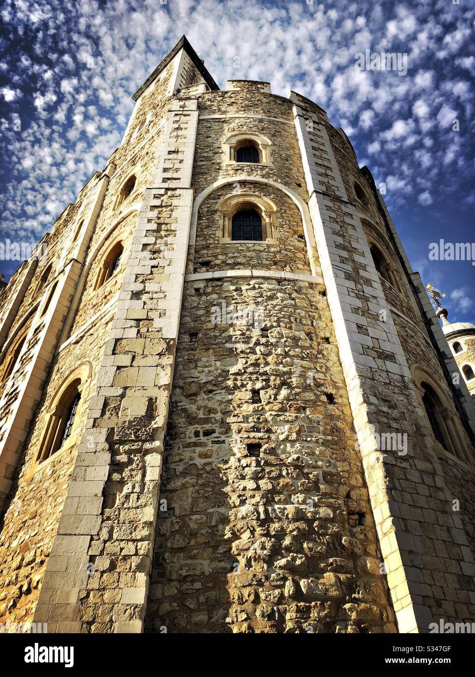 Un'inquadratura ad angolo basso su un angolo di pietra circolare della Torre Bianca. Torre medievale all'interno del complesso del castello e della fortezza di Londra - Immagine stock catturata con smartphone