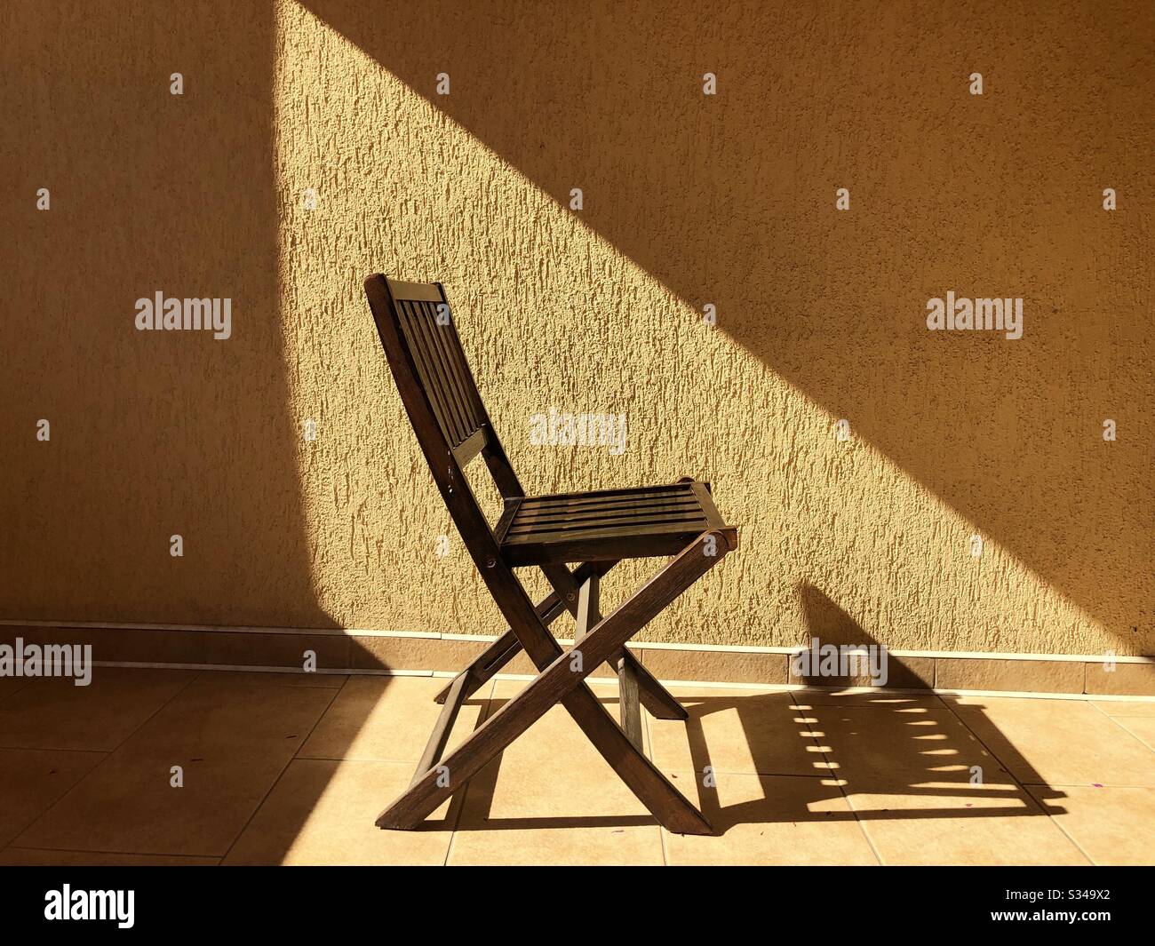 Sedia in legno alla luce del sole Foto Stock