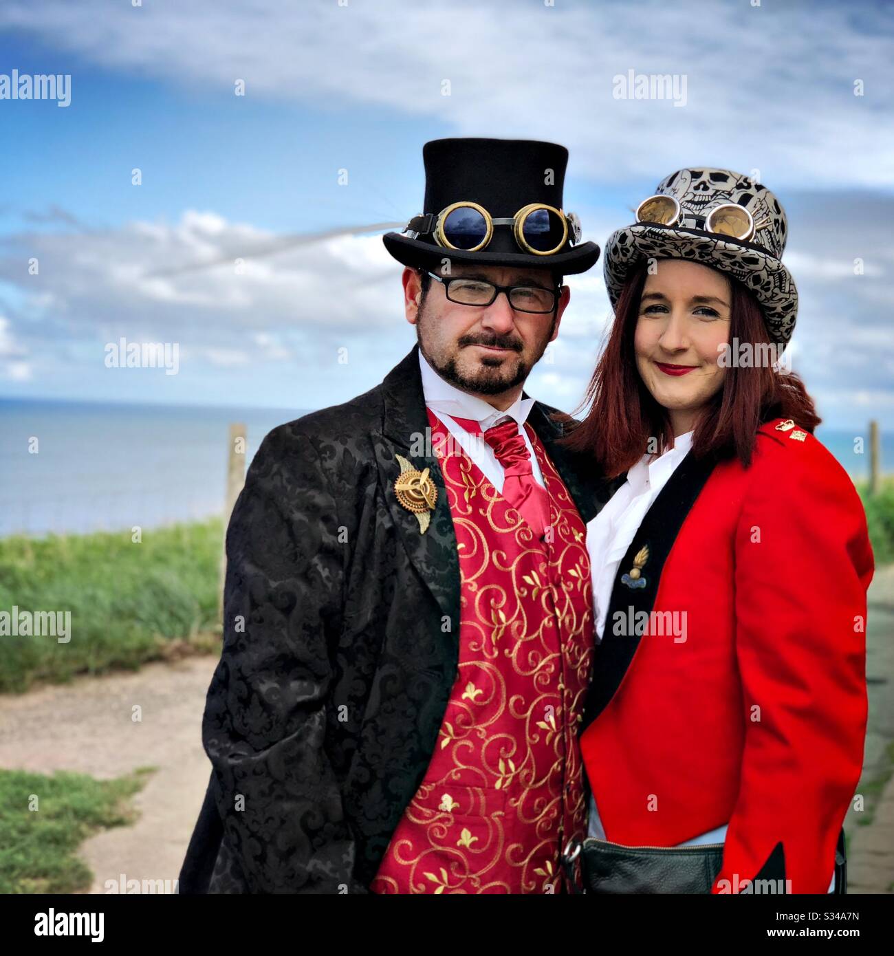 Una coppia di uomini e donne è vista vestita come steampunks durante l'evento cosplay del fine settimana di Whitby Goth - Immagine stock catturata con smartphone