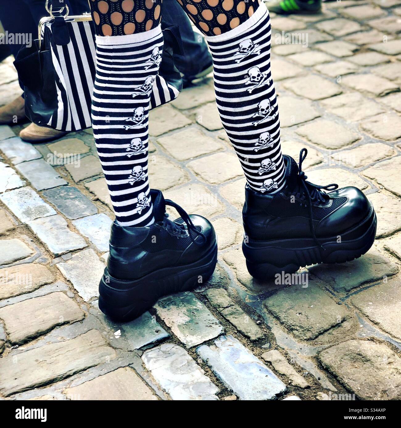 Persona in un costume creativo durante un evento cosplay. Weekend di Whitby Goth. Calzini alti a righe in bianco e nero con scheletro Foto Stock