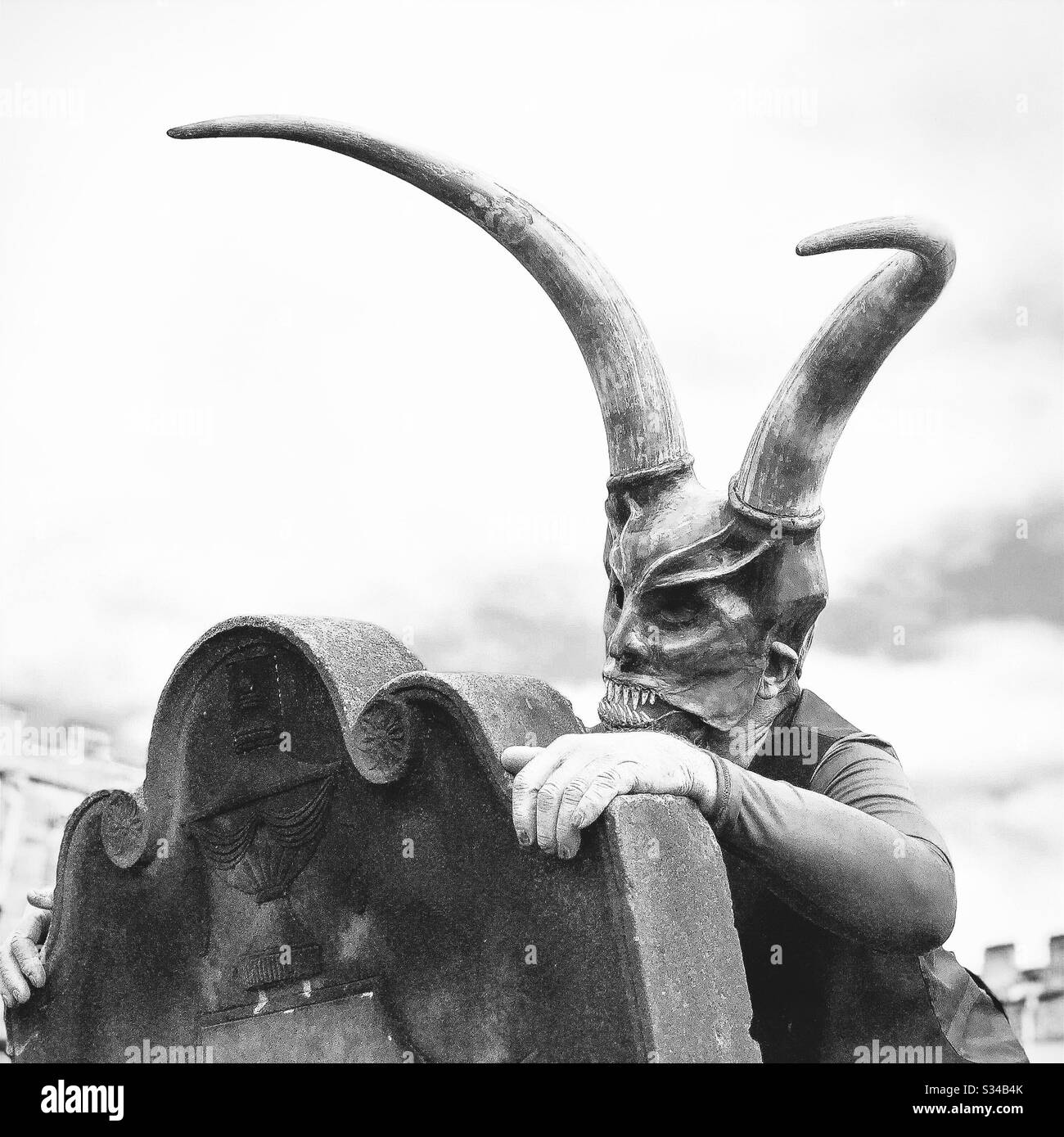 Persona in un costume creativo durante un evento cosplay. Weekend di Whitby Goth. Uomo in maschera mostro e corna, demone al cimitero - Immagine stock catturata con smartphone