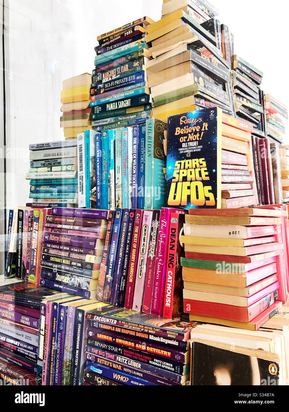 Pile di libri cartacei vintage organizzati in un mucchio a forma di piramide, con un mix di spine e bordi di carta Foto Stock