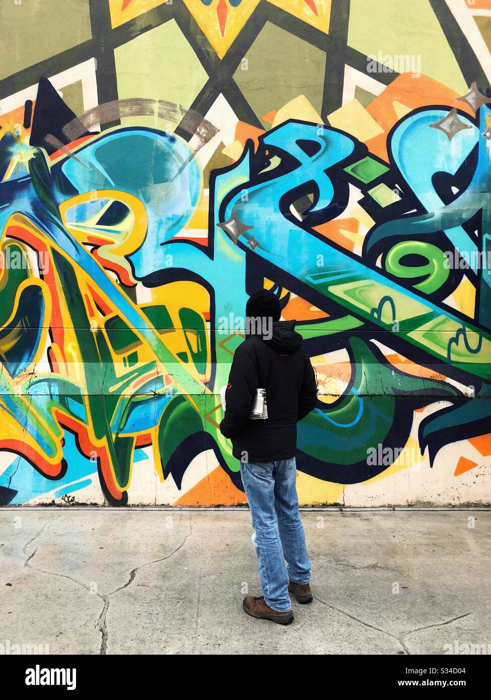 L'uomo sta cercando di capire il significato dei graffiti murali in Tacoma Foto Stock