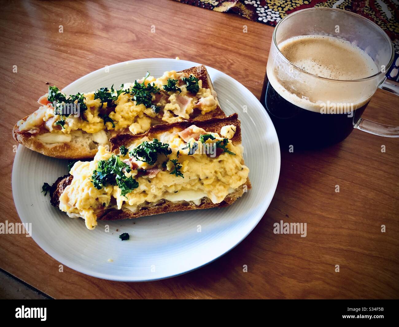 Uova strapazzate su pane tostato con una tazza di caffè nero, colazione fatta in casa - Immagine stock catturata con smartphone