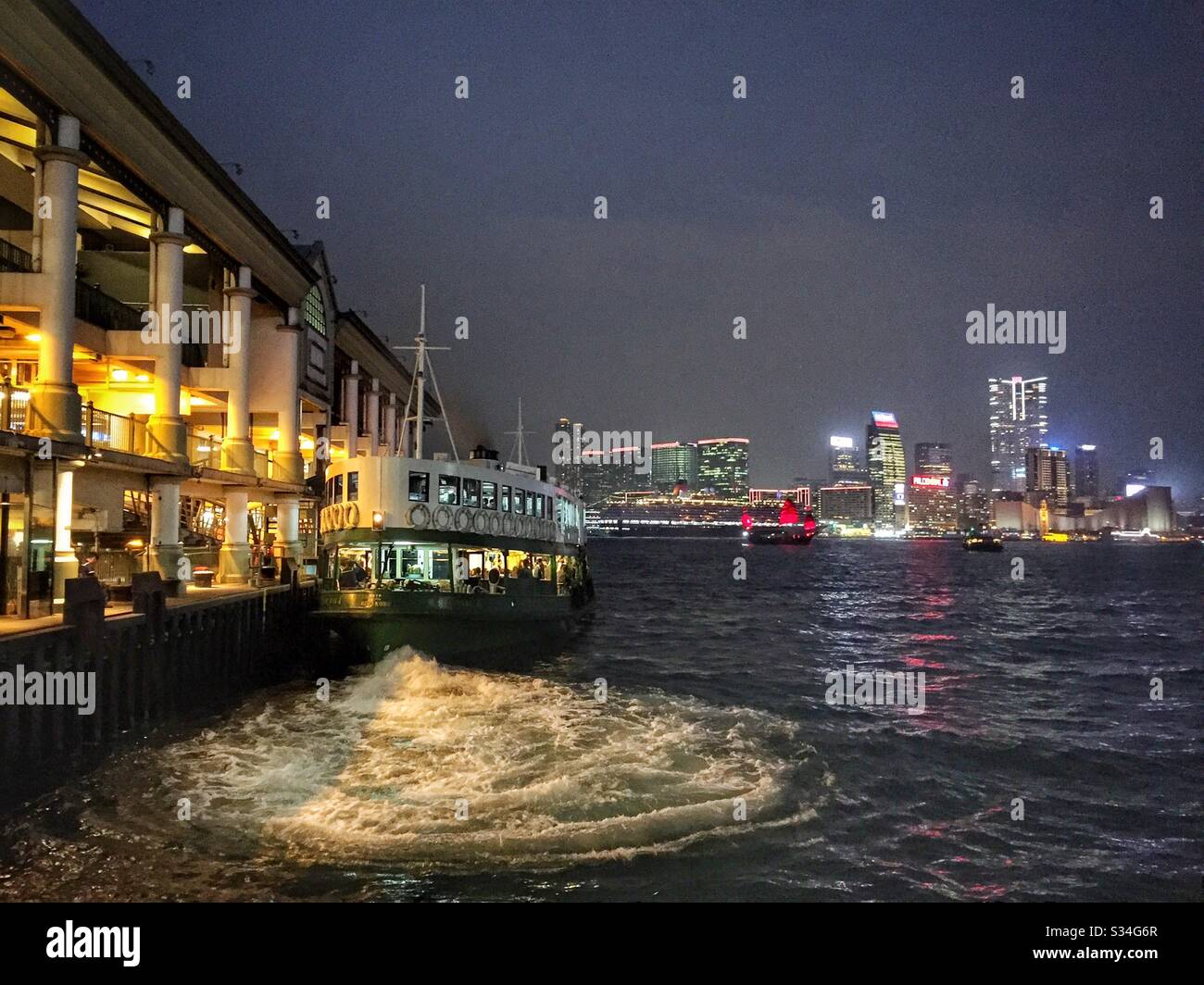 Uno Star Ferry parte dall'isola di Hong Kong per portare i passeggeri attraverso il Victoria Harbour a Tsim Sha Tsui a Kowloon Foto Stock