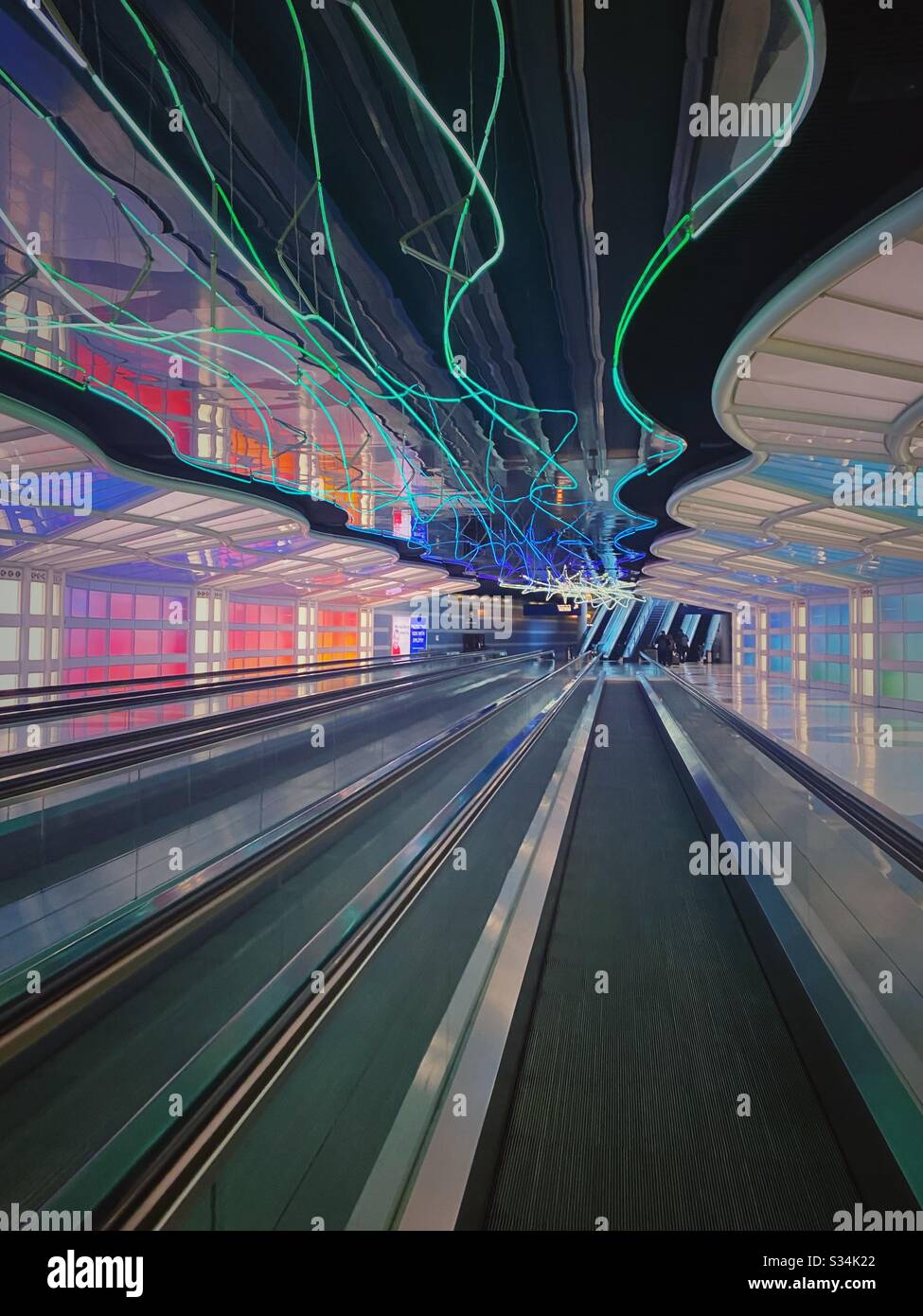 O’Hare International Airport a Chicago, Illinois. Tunnel tra i concorsi B e C del terminale Unito con luci al neon colorate in movimento e passaggio pedonale in movimento. Foto Stock