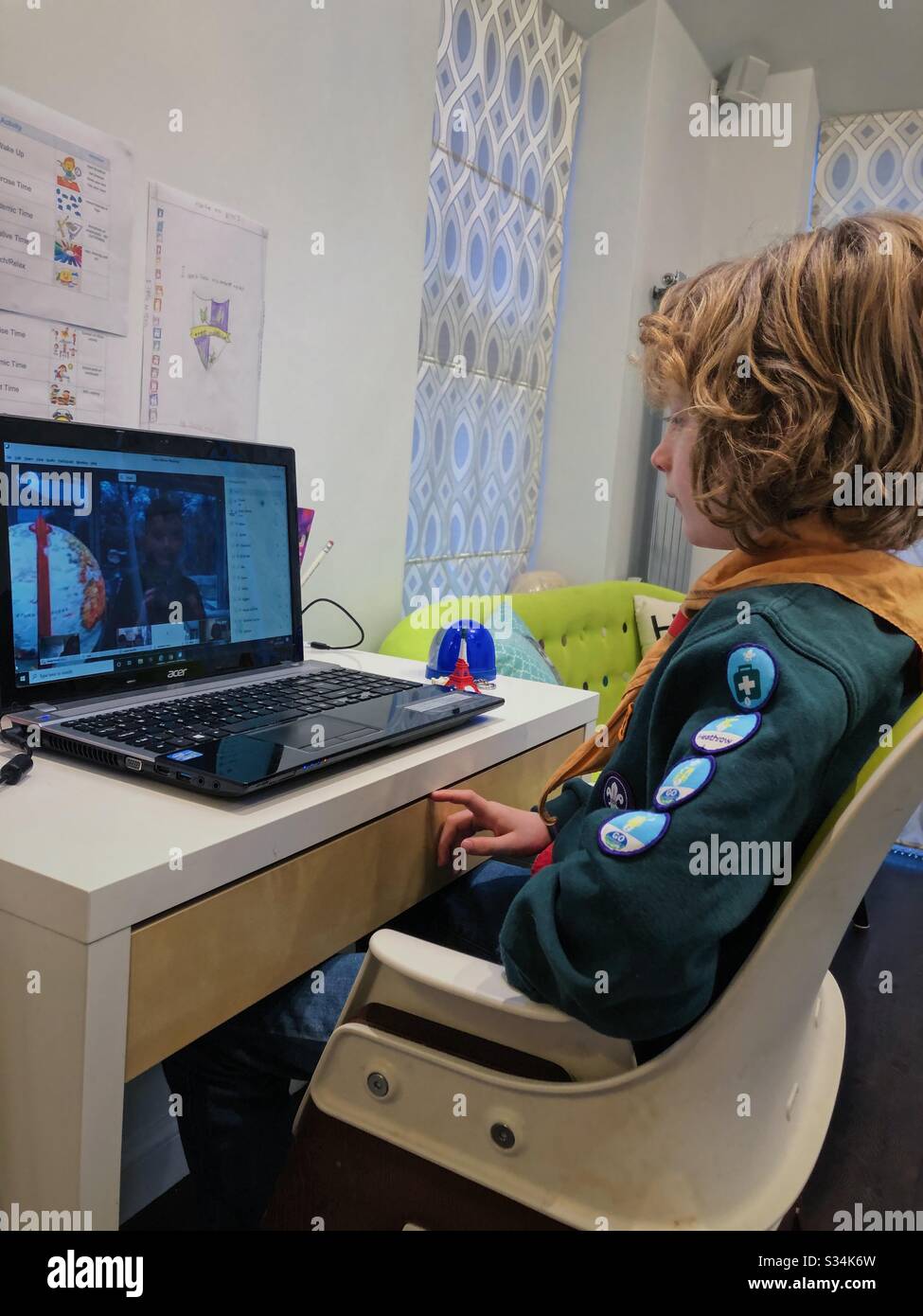 Cub Scout che ha online WebEx incontro con il suo pacchetto durante il Regno Unito Coronavirus lockdown. - Immagine stock catturata con smartphone