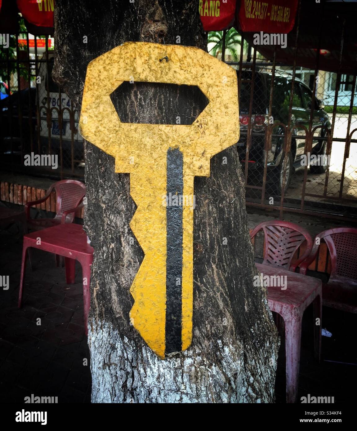 Un cartello in legno fatto dall'uomo appende su un tronco d'albero. - Immagine stock catturata con smartphone