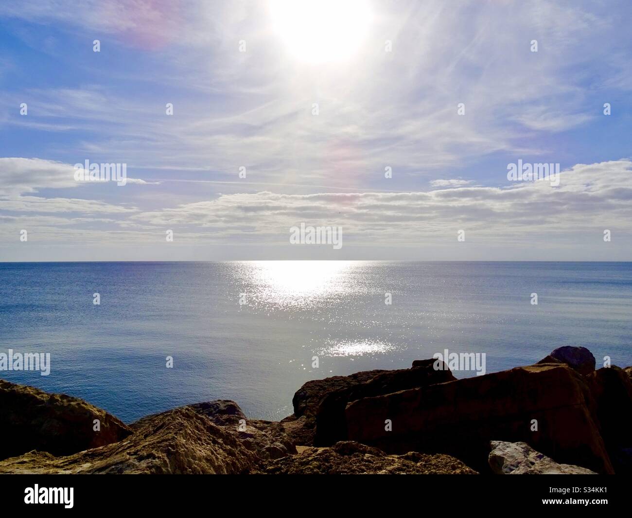 Tranquillo paesaggio marino con il sole che splende sul mare scintillante nel sud della Spagna Foto Stock