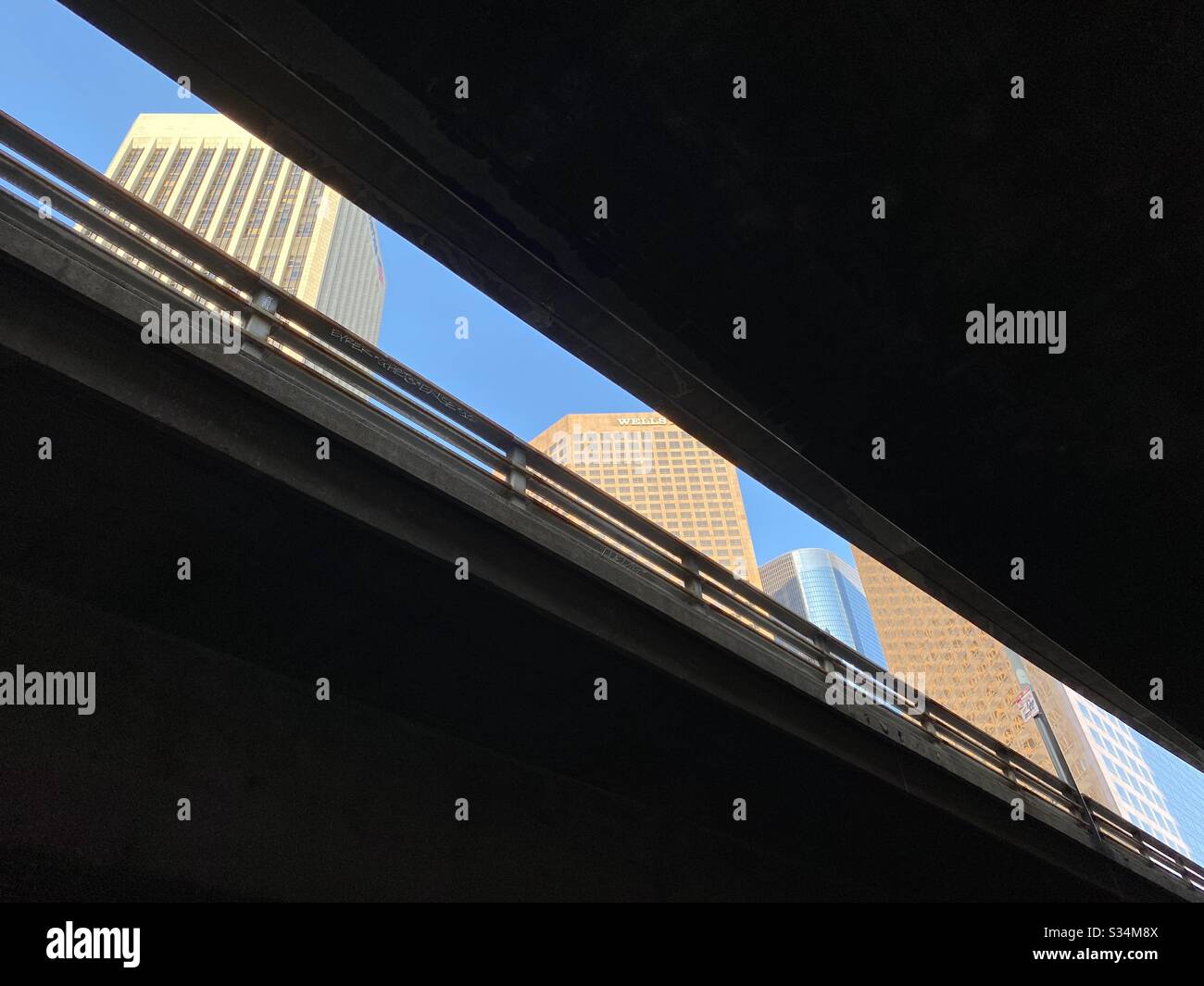 LOS ANGELES, CA, MAR 2020: Dettaglio dei grattacieli nel quartiere finanziario del centro città, visto dallo spazio scuro sotto un cavalcavia - Immagine stock catturata con smartphone