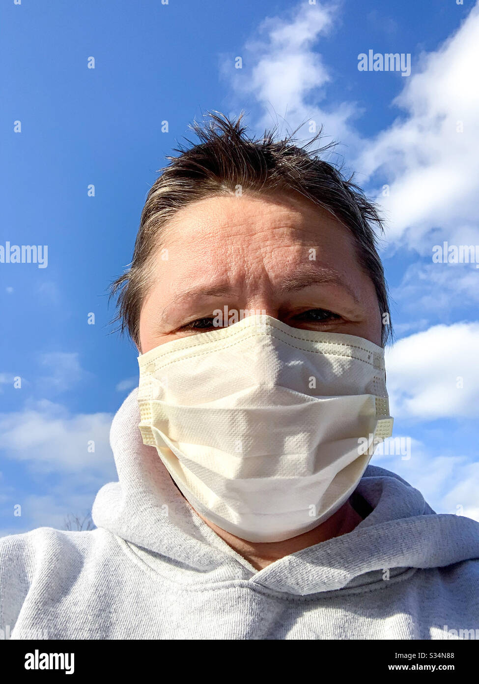 Donna che indossa una maschera chirurgica per il viso all'aperto. Foto Stock