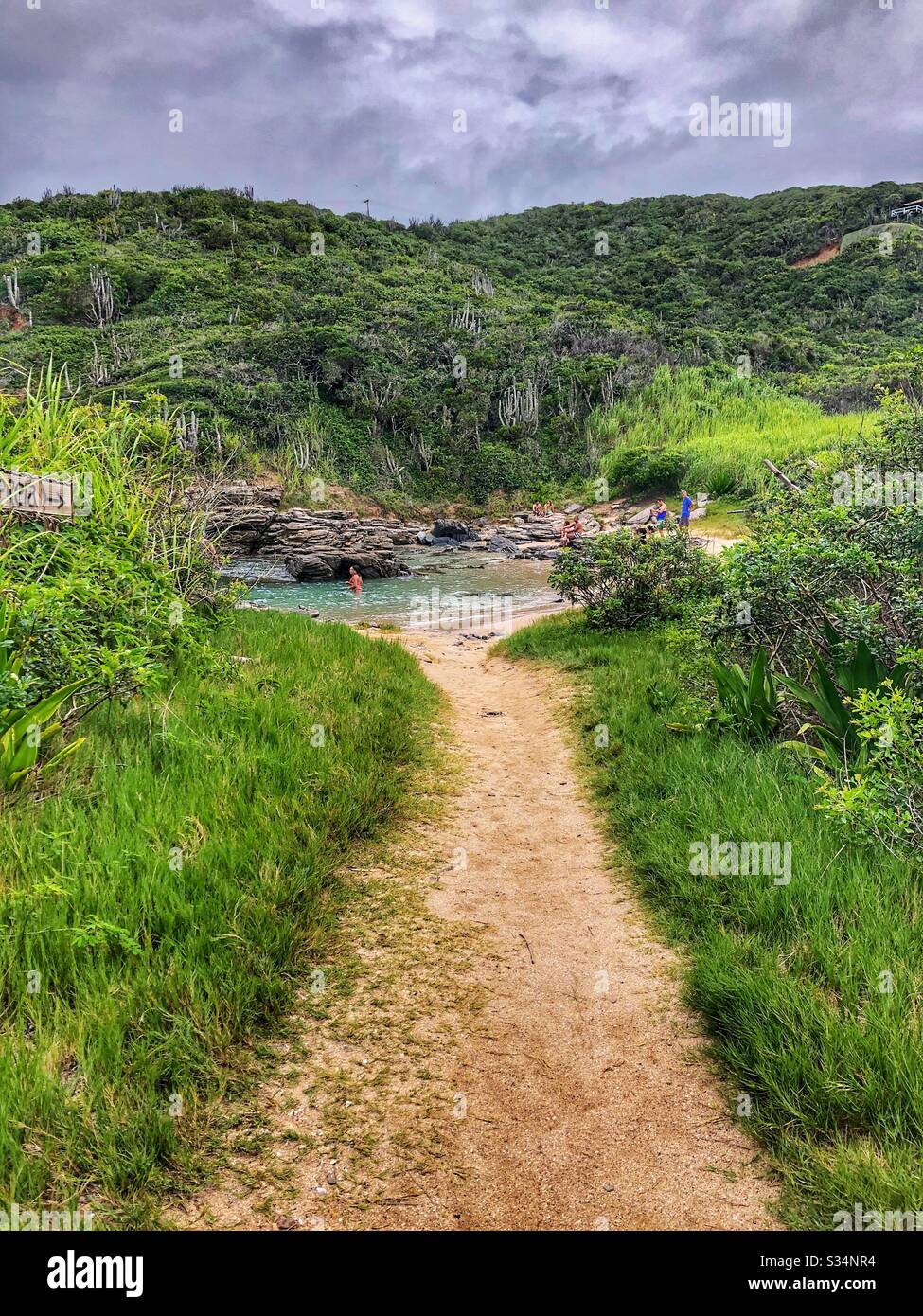 Un sentiero che conduce ad una piccola spiaggia appartata a Buzios, Brasile. Foto Stock