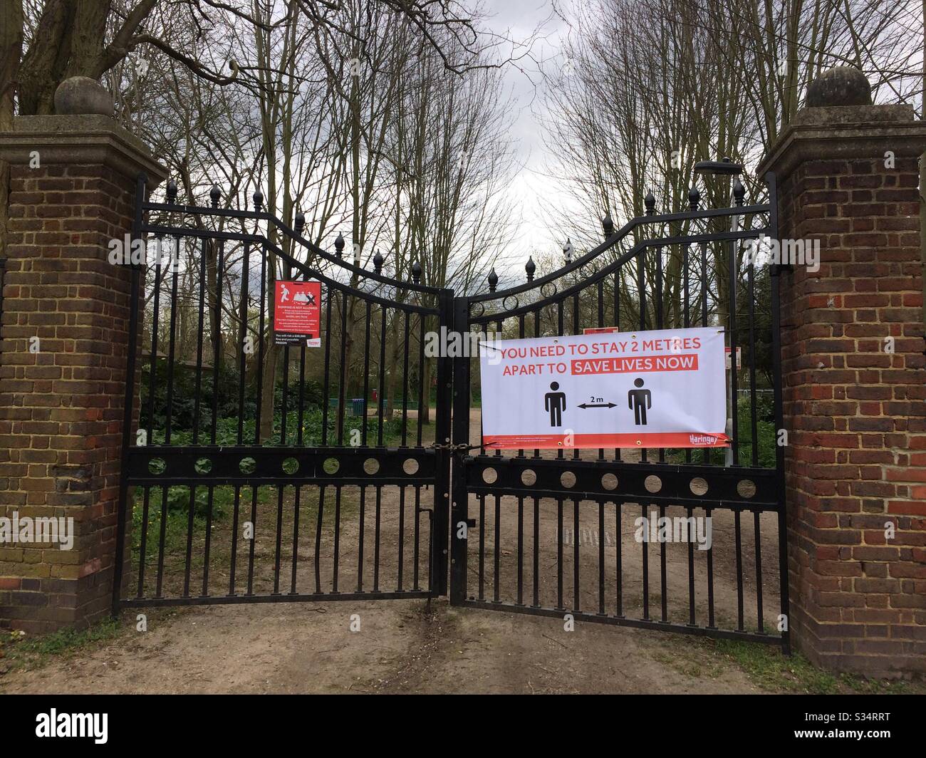 Negli spazi pubblici di Haringey viene eretta una nuova segnaletica per mostrare la distanza di due metri che le persone devono mantenere durante l'attività fisica durante lo scoppio del Coronavirus a Londra. - Immagine stock catturata con smartphone