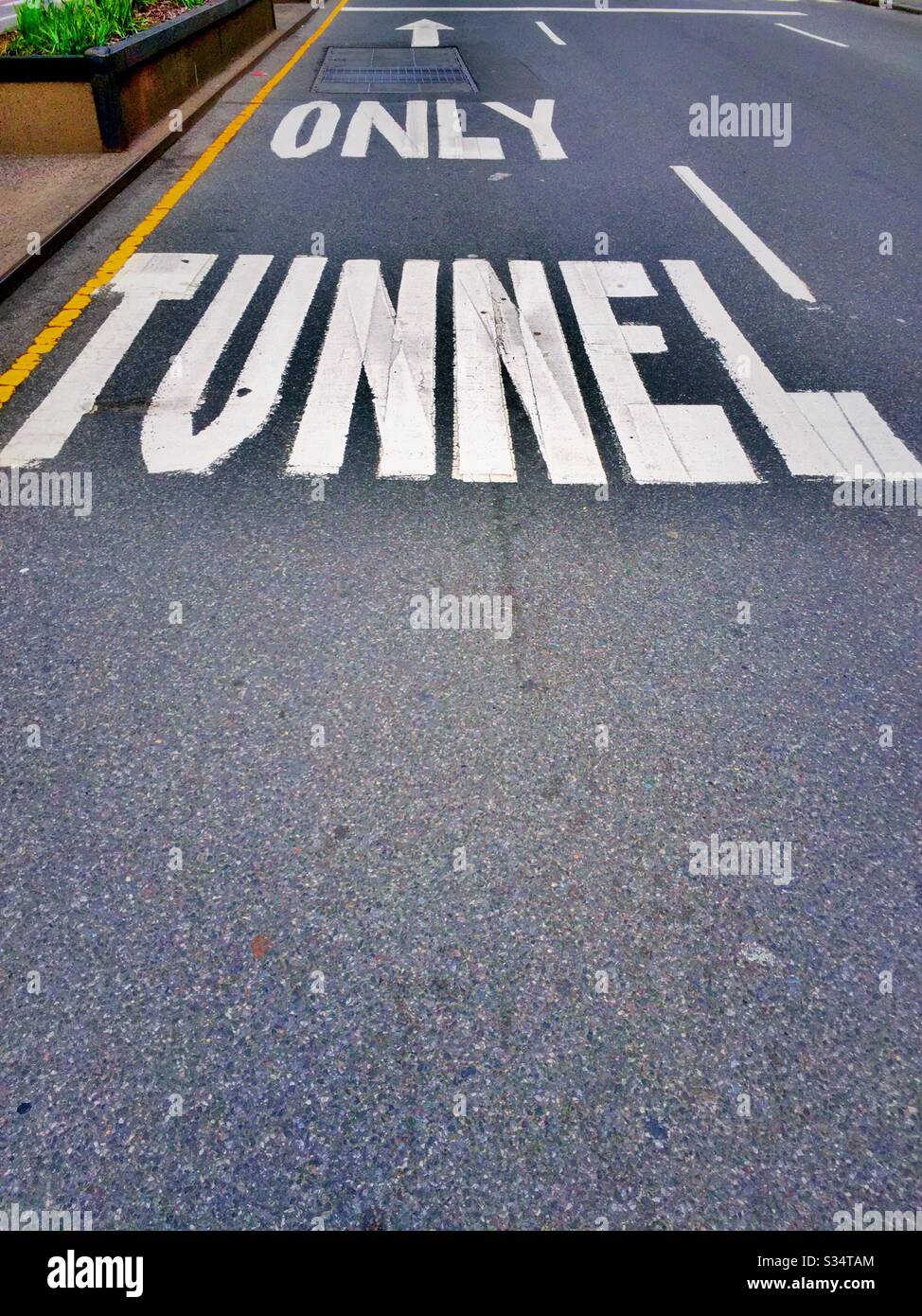 Street Lane con "tunnel only" che fornisce informazioni direzionali, USA - Immagine stock catturata con smartphone