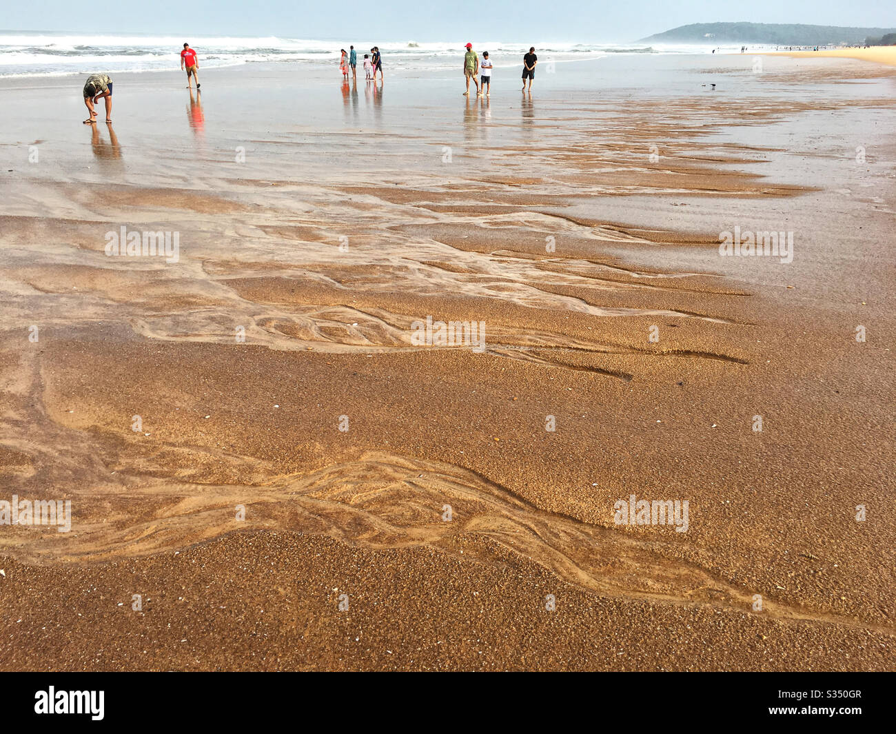 I turisti godono della brezza mattutina sulla spiaggia di Calangute a Goa, India. Foto Stock