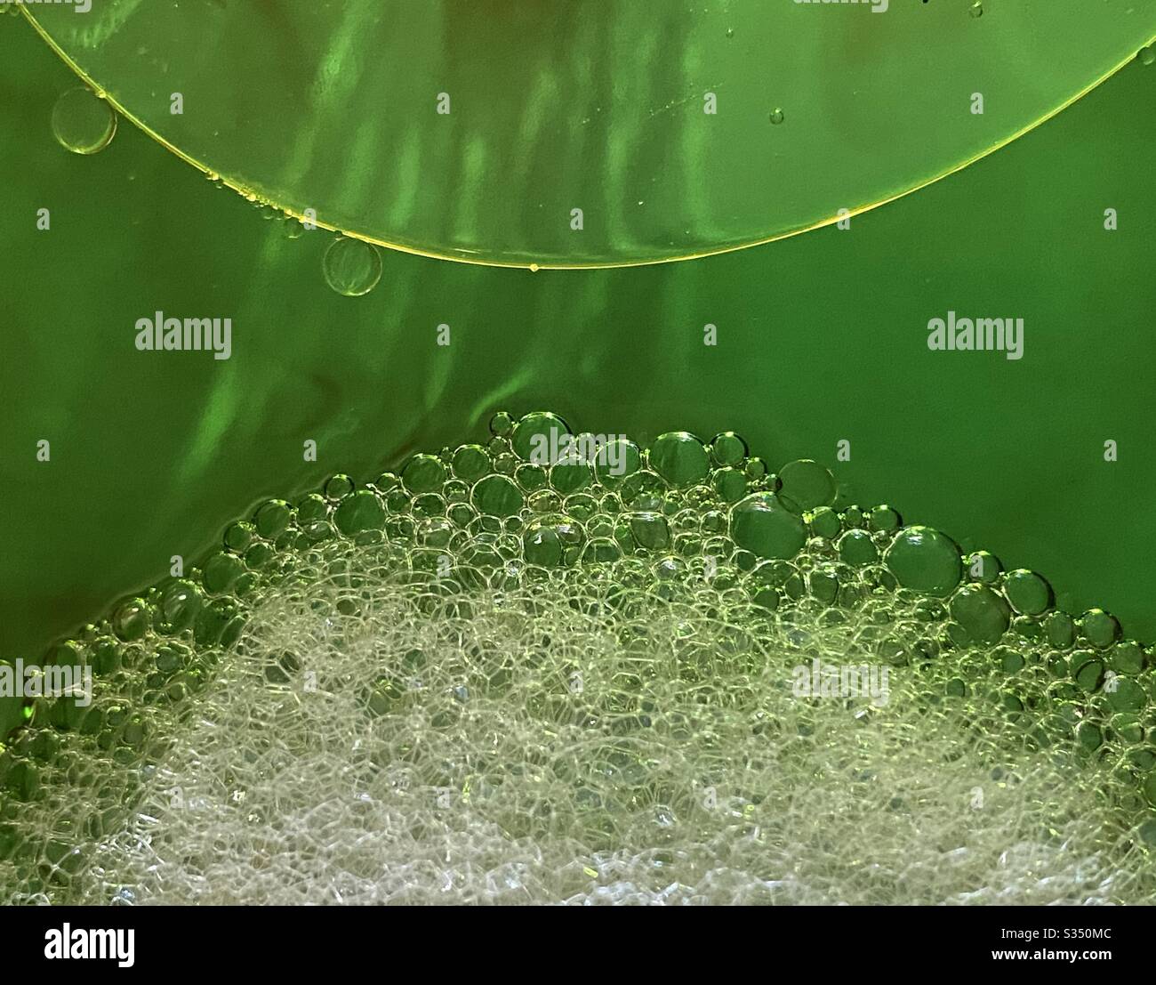 Sfondo astratto di bolle di sapone, goccia di olio semicircolare su acqua verde - Immagine stock catturata con smartphone