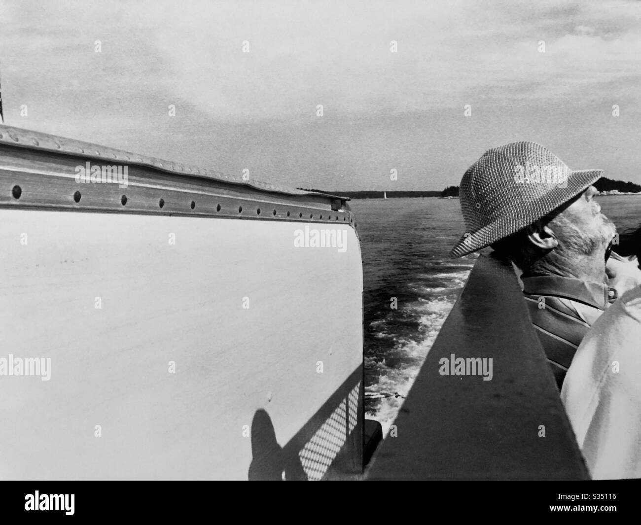 Uomo anziano che si rilassa sul cappello della barca sopra la testa foto in bianco e nero - Immagine stock catturata con smartphone
