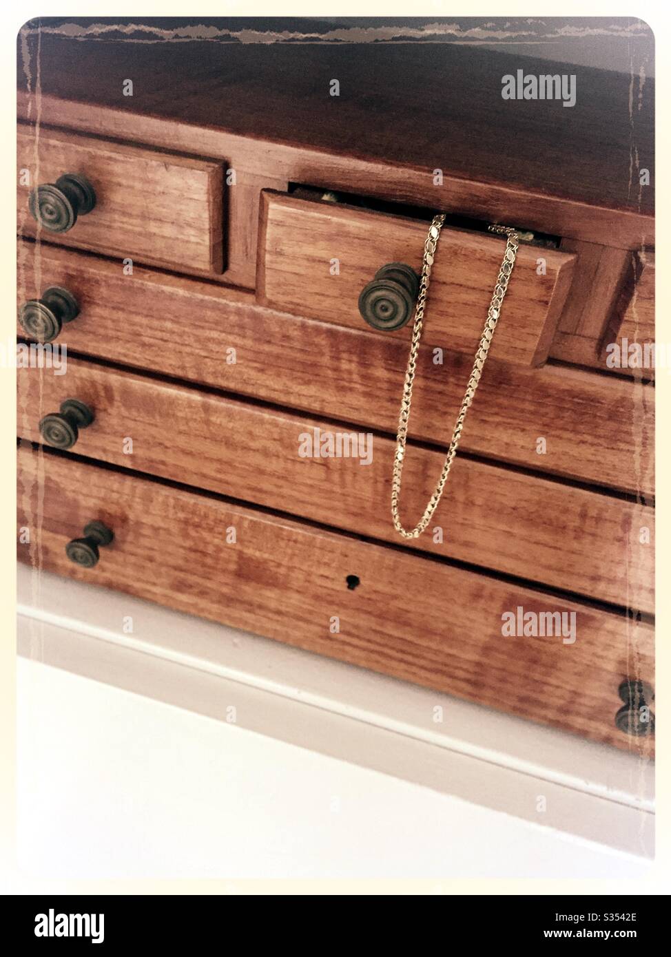 La scatola di gioielleria in legno artigianale vintage presenta molti cassetti con una catena d'oro in uno Foto Stock