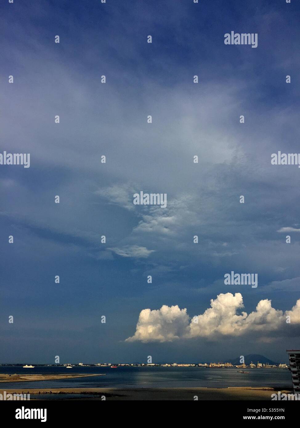 Nuvole lontane si aggirano sul mare. Foto Stock