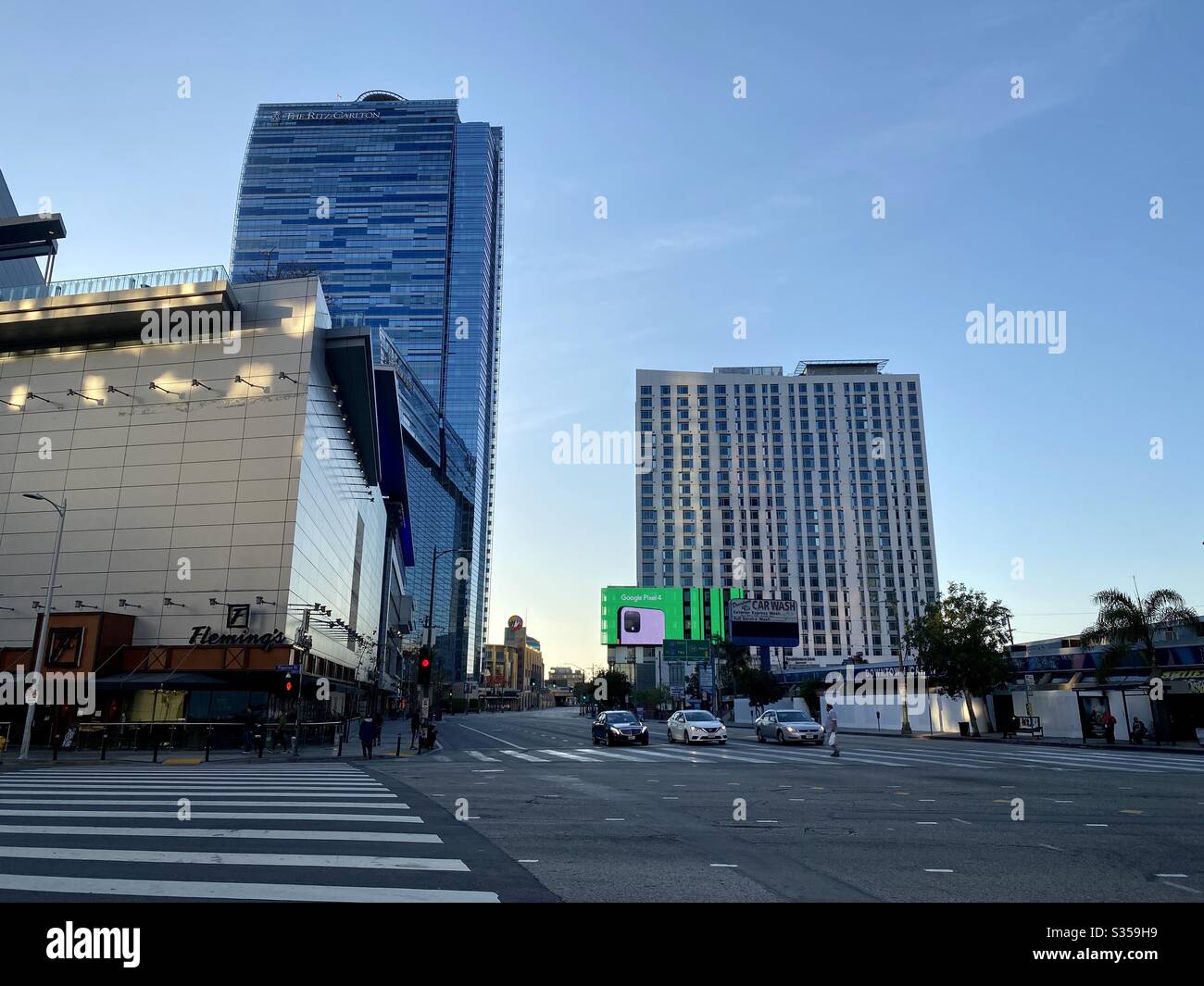 LOS ANGELES, CA, MAR 2020: Persone che attraversano la strada con traffico leggero vicino A LA Live sport e luoghi di intrattenimento durante gli ordini di "soggiorno a casa" coronavirus nella zona di South Park del centro Foto Stock