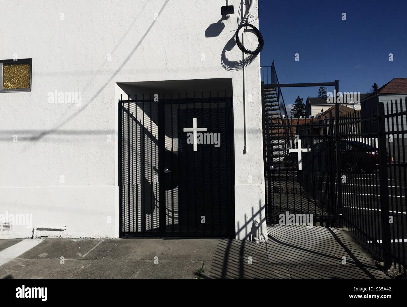 Croci bianche su porte nere, la porta posteriore della chiesa cristiana di Giosuè in West Oalkand, California. - Immagine stock catturata con smartphone