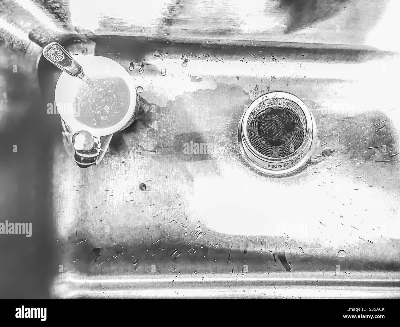 Tazza di caffè nel lavandino della cucina in bianco e nero Foto Stock