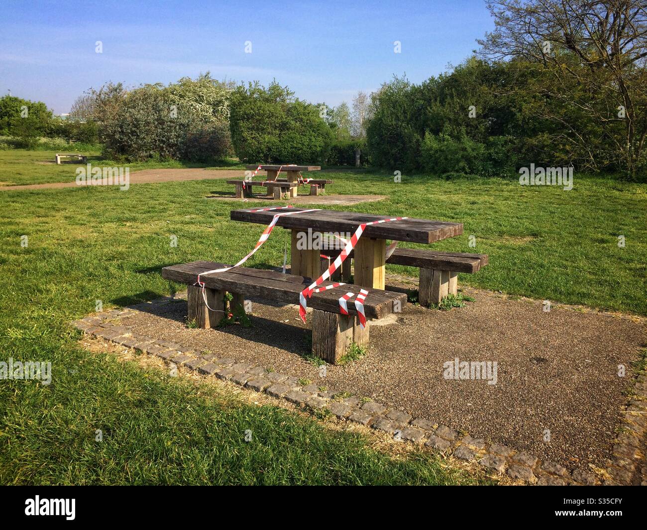 I tavoli da picnic in un parco londinese sono registrati per impedire che le persone li utilizzino durante l'epidemia di Coronavirus - Immagine stock catturata con smartphone